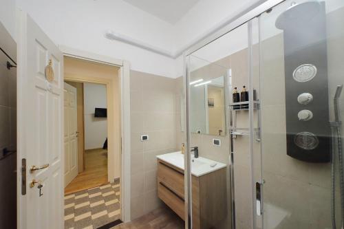 a bathroom with a sink and a glass shower at Stella Polare Sensorial Home in Lido di Ostia