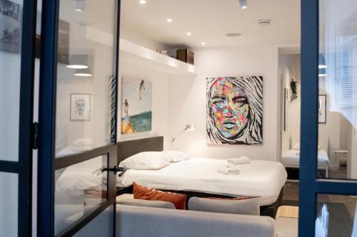 a bedroom with two beds and a painting on the wall at Spui apartment in center in Amsterdam