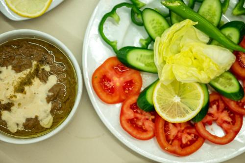 a table with a plate of vegetables and a bowl of dip at Soft Hotel in Cairo