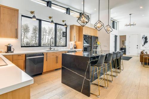 an open kitchen with wooden cabinets and black countertops at Mtn Views and Private Hot Tub Luxe Tetonia Retreat in Tetonia
