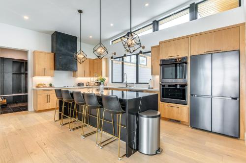 a kitchen with a large island with bar stools at Mtn Views and Private Hot Tub Luxe Tetonia Retreat in Tetonia
