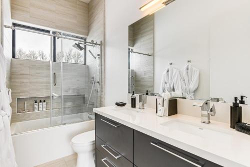 a bathroom with a tub and a toilet and a sink at Mtn Views and Private Hot Tub Luxe Tetonia Retreat in Tetonia
