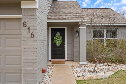 a house with a black door with areath on it at Pool,Games & Chill Vibes in Cedar Park