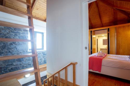 a bedroom with a bed and a large window at Casa das Escaleiras by Atlantic Holiday in Porto Moniz