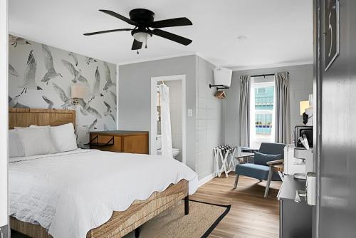a bedroom with a bed and a ceiling fan at Seabirds Motel At Kure Beach in Kure Beach