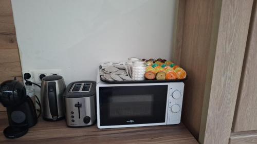 a microwave with a shelf on top of it at Le caillou Blanc in Charleroi