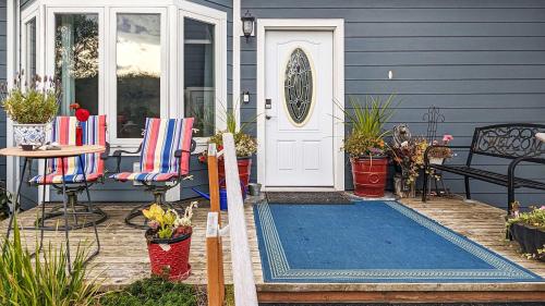 a blue house with a blue door and a patio at Sq Sequim Sunrise Apartment in Sequim