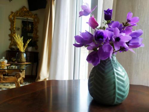 a vase with purple flowers sitting on a table at Διώροφο πέτρινο σπίτι με θέα Agiasos Classic Stone House in Agiásos