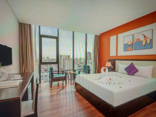 a hotel room with a large bed and a desk at Agena Hotel City Center in Da Nang