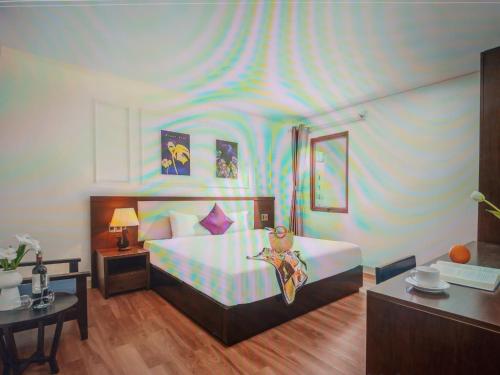 a bedroom with a large bed with a blue and purple ceiling at Agena Hotel City Center in Da Nang