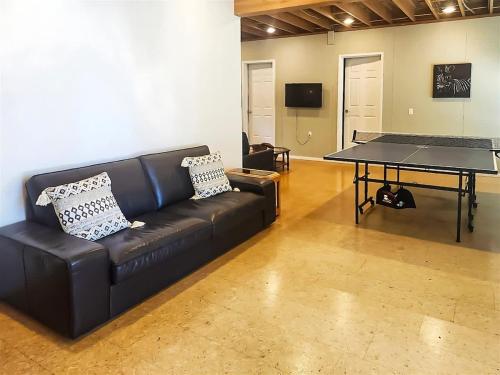 a black couch in a room with a ping pong table at Sq Gretas Place in Sequim