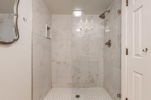 un bagno bianco con doccia e porta in vetro di All New Historic Charmer in the Heart of Durango a Durango