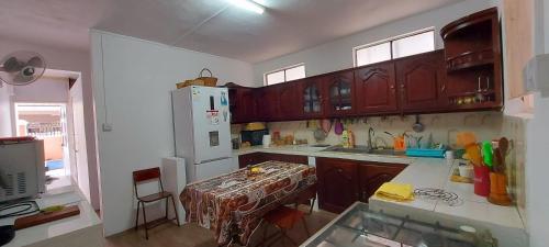 a kitchen with wooden cabinets and a table in it at Tamarin Beach House in Tamarin