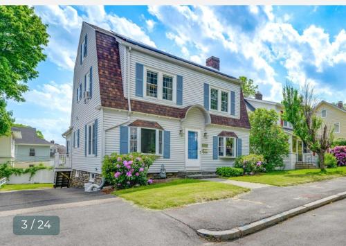 a white house with blue shutters on a street at Velocity Residence in Worcester