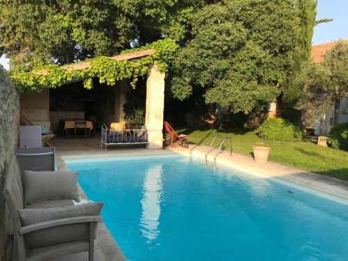 une piscine dans une cour avec une maison dans l'établissement Maison de campagne en plein village, à Fontvieille