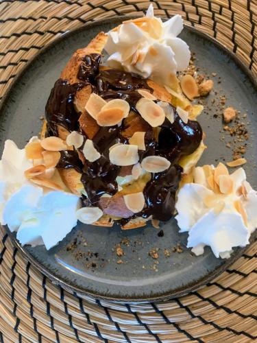 a plate with a dessert with chocolate and shells on it at Villa'S in Zaouiet Bouzarktoune