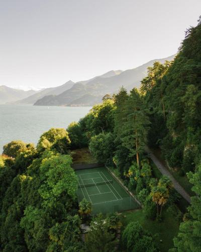 an aerial view of a tennis court on a hill next to the water at Grand Hotel Villa Serbelloni - A Legendary Hotel in Bellagio