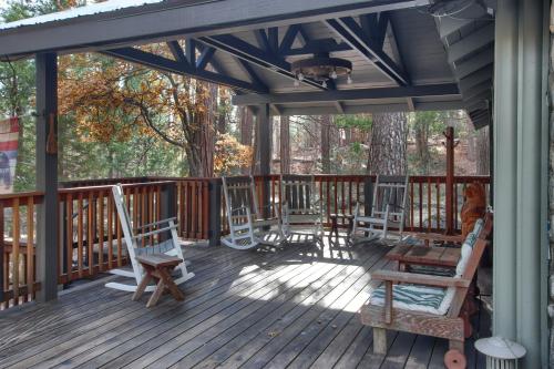 a deck with rocking chairs and awning on a house at The Little Creek Cabin in Wawona