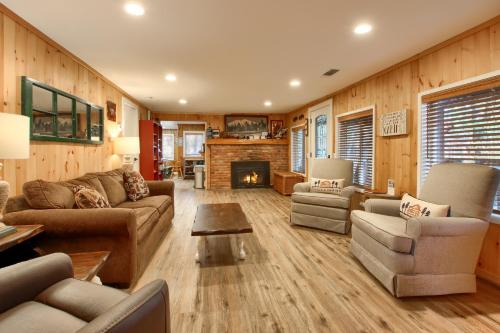 a living room with a couch and chairs and a fireplace at The Little Creek Cabin in Wawona