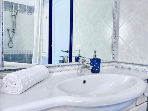 ein weißes Badezimmer mit Waschbecken und Dusche in der Unterkunft Villa Corallo con vista mozzafiato in Costa Paradiso