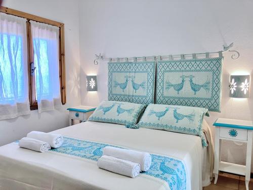 ein Schlafzimmer mit einem großen Bett mit blauen Akzenten in der Unterkunft Villa Corallo con vista mozzafiato in Costa Paradiso