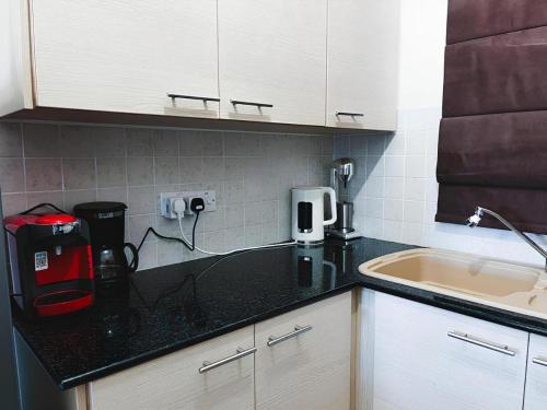 a kitchen with a black counter top and a sink at Déjà Blue Apartment Kyklades BC7 - workspace, pool, gym, nearby beach in Protaras
