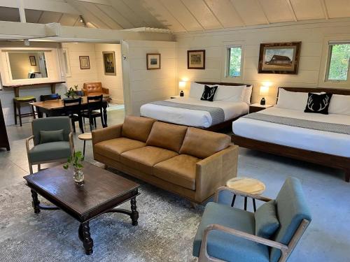a hotel room with two beds and a couch and a table at The Wells Cashiers in Cashiers