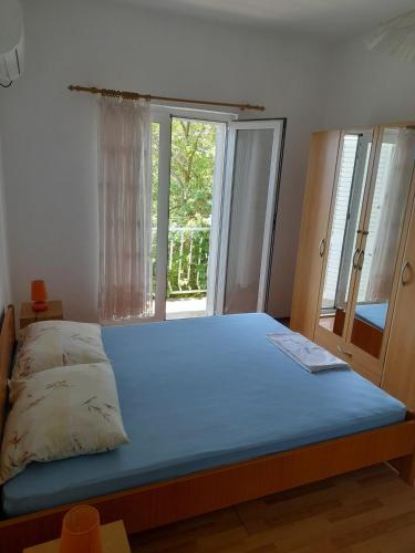 a bedroom with a bed with a window and a blue mattress at Marijana - One bedroom with balcony in Babino Polje