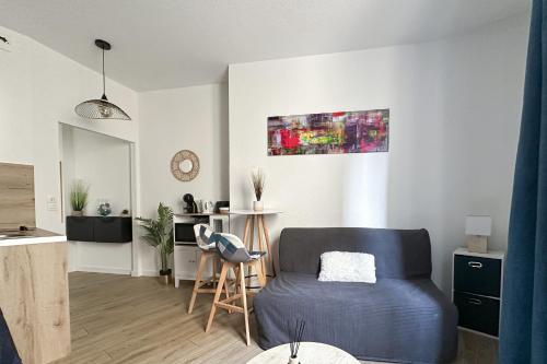 un salon avec un canapé bleu et une cuisine dans l'établissement #HT Le Lorraine Studio hyper-centre fully equipped, à Grenoble