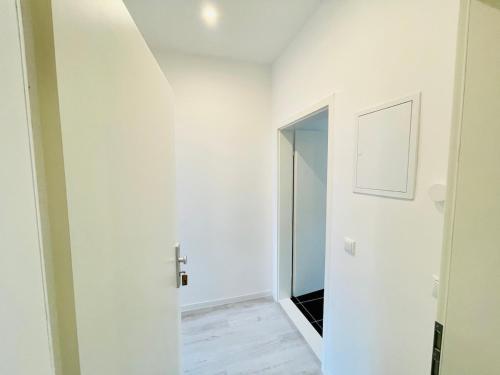 a hallway with white walls and a mirror at Mitten in Meißen moderne Ferienwohnung No 5 in Meißen