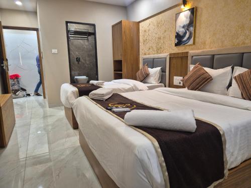 a hotel room with two beds with white sheets at Galaxy Stays BKC in Mumbai