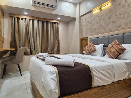 a bedroom with a bed and a desk in a room at Galaxy Stays BKC in Mumbai