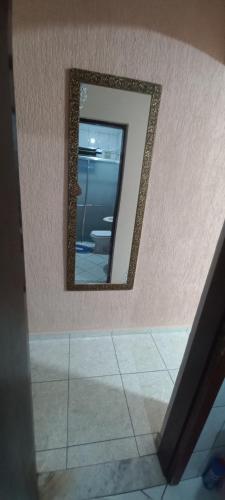 a mirror on a wall in a bathroom at Hostel Recanto do Descanso in Guarulhos