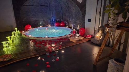 a hot tub in a room with candles and flowers at Elite Apartment SPA in Catania