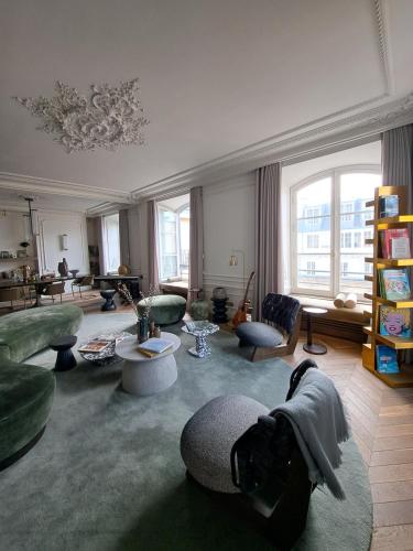 - un salon avec des canapés et des chaises ainsi qu'une grande fenêtre dans l'établissement APPARTEMENT PLACE VENDÔME PARIS 1er RIVE DROITE, à Paris
