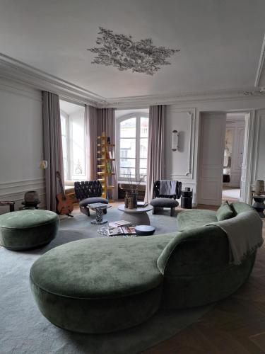 - un grand salon avec un grand canapé et des chaises dans l'établissement APPARTEMENT PLACE VENDÔME PARIS 1er RIVE DROITE, à Paris