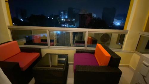 a balcony with two chairs and a window with a view at Résidence hôtelière MEDOM Palace, Bastos in Yaoundé