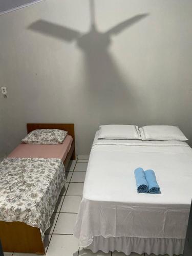 two beds in a room with a shadow on the wall at Hostel Dourado in Barra do Garças