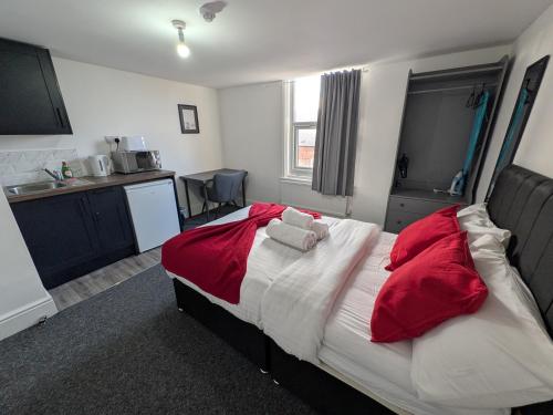 a bedroom with a large bed with red pillows at Comfortable Stay - NG7 in Nottingham