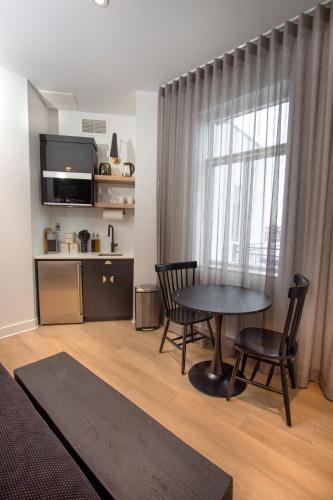 a living room with a table and chairs and a kitchen at Studio #15 - Self Check-In - Plateau - St-Denis in Montréal