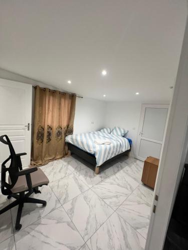 a bedroom with a bed and a chair at Chambre dans un appartement in Ormesson-sur-Marne