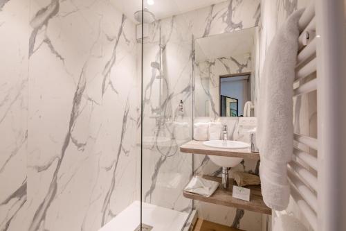 a bathroom with a sink and a shower at Hôtel La Plage in Sainte-Maxime