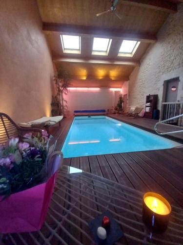 a large swimming pool in a room with at Aux quatre coins du monde in Champvoux