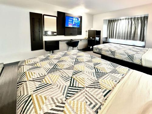 a hotel room with two beds and a flat screen tv at Motel 6-Simpsonville, SC - Greenville in Simpsonville