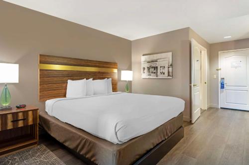 a large white bed in a hotel room at Best Western Cedar Inn & Suites in Angels Camp
