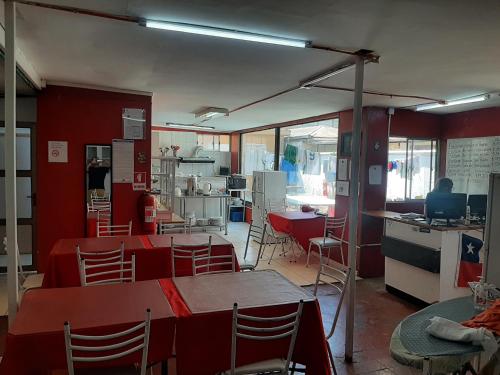 a room with tables and chairs and a kitchen at Hostal Estadio Nacional in Santiago