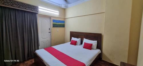 een slaapkamer met een bed met 2 rode kussens bij One Bedroom studio apartment with kitchen in Karachi