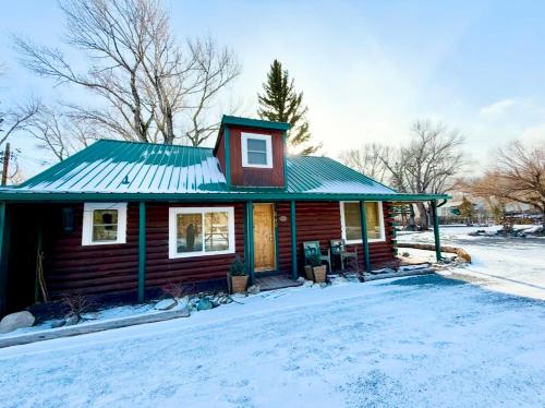 a house with a green roof in the snow at Chinook Winds Lodge in Dubois