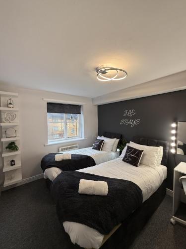 a bedroom with three beds with black and white at 2 Bed Apartment in Greenwich, Free Parking, DLR in London