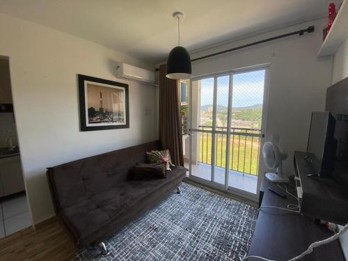 a living room with a couch and a large window at 15 minutos da praia ExpocentroCentro Greenvaley in Camboriú